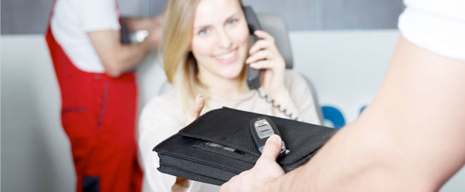 kobieta rozmawiająca przez telefon komórkowy, trzymająca w ręku portfel
